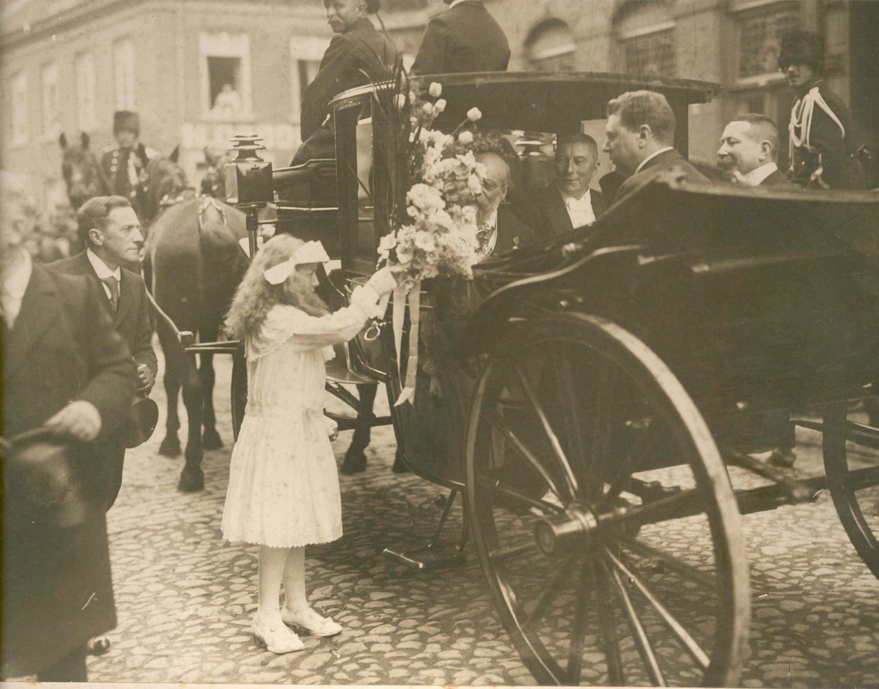 Een bruidje biedt Dr. P.J.H. Cuypers  bloemen aan bij gelegenheid van zijn 90e verjaardag Dr. P.J.H. Cuypers