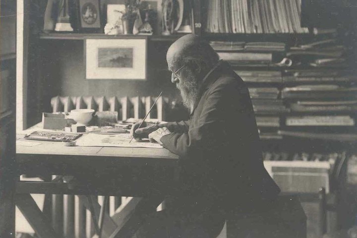 Foto van Dr. P.J.H. Cuypers, schilderend aan  werktafel.