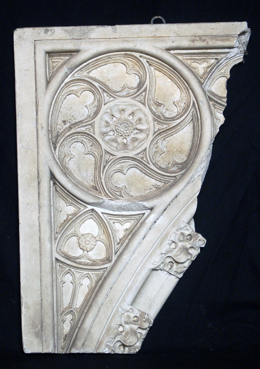Afgietsel van de linkerbovenhoek van een neogotisch raam met uitgewerkt rozet en driepas