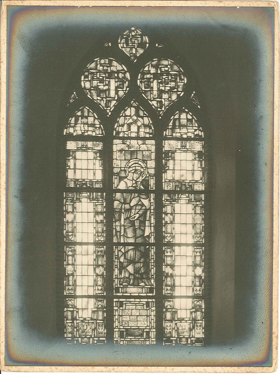 Foto van een driedelig glas-in-loodraam in een kerk.
