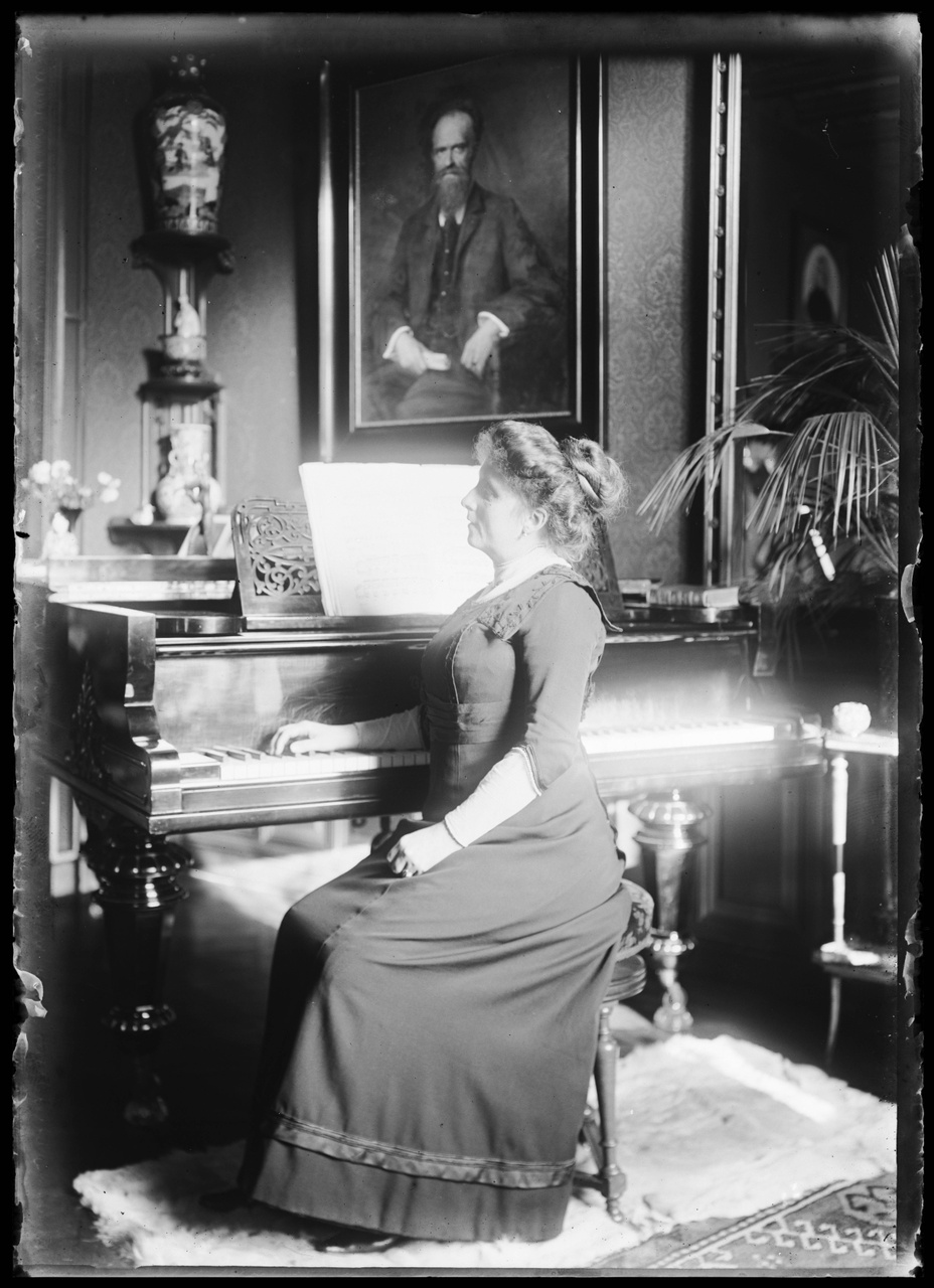 Glasnegatief van Delphine Povel achter piano