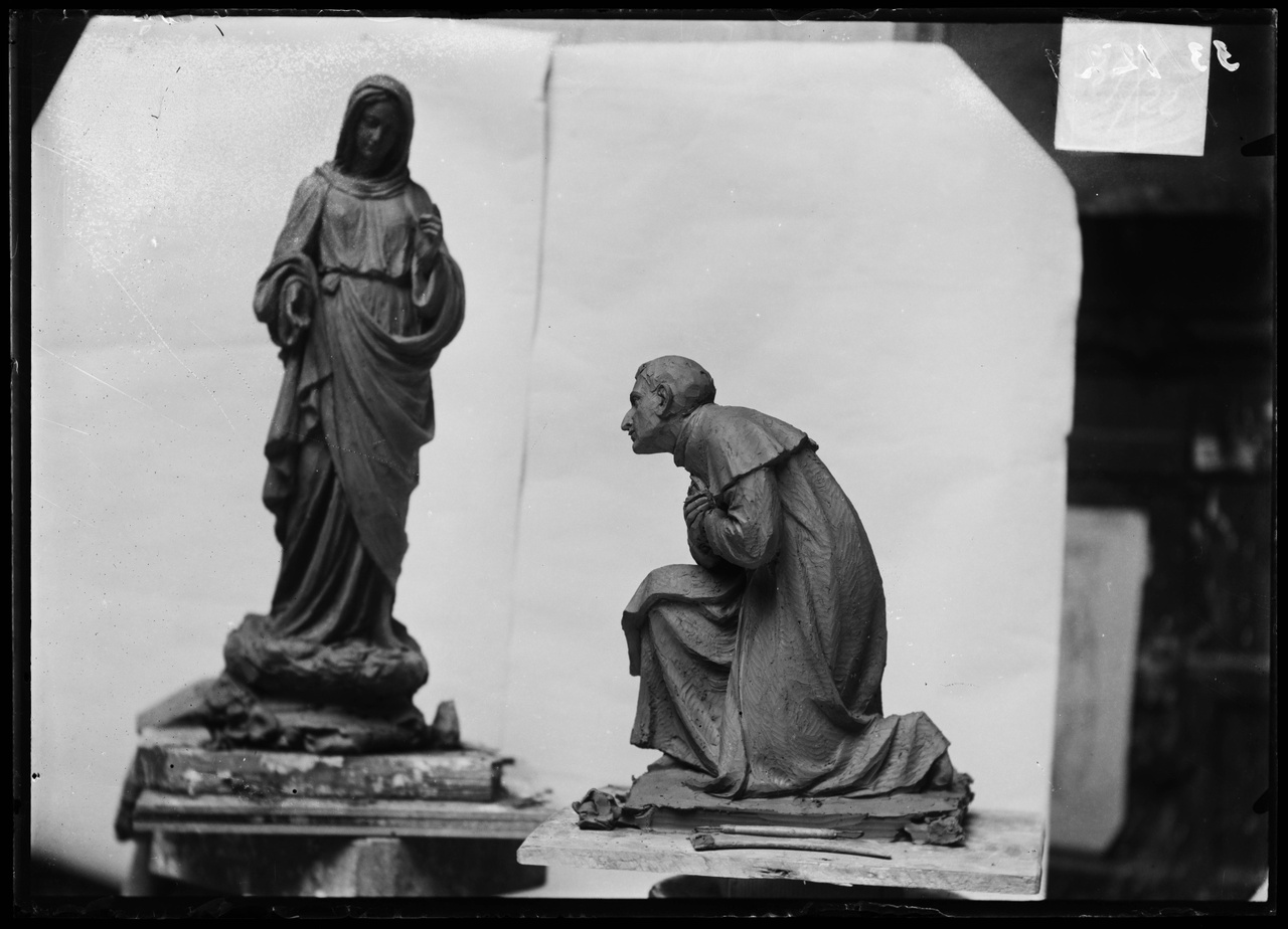 Glasnegatief van foto van producten uit de Cuypers' Kunstwerkplaatsen: "Foto van een beeldje van een vrouw met hoofddoekk en van een beeldje van een knielende priester".