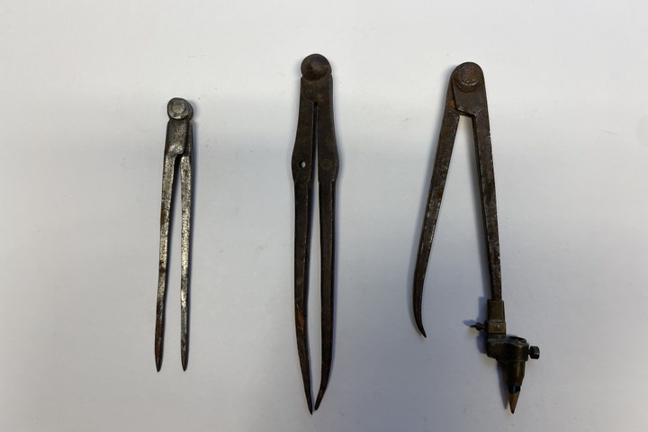 Drie metalen passers, waarvan één met potloodje